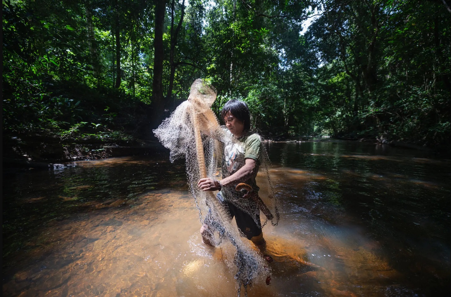 Ma’ruf with a fishing net on the River Rasa. There are rumors that the river is gradually being overfished by residents of Antutan, a village with a thriving palm oil plantation.